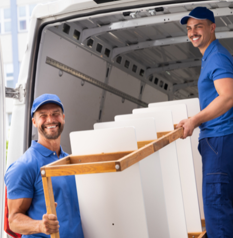 Two smiling delivery men unloading a new appliance from their van.